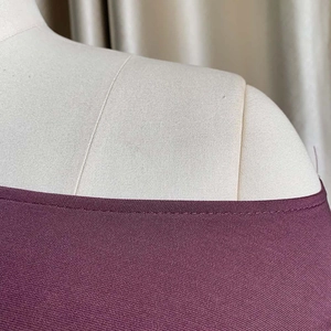 Detalle de la costura del hombro y tela morada texturizada del conjunto de falda