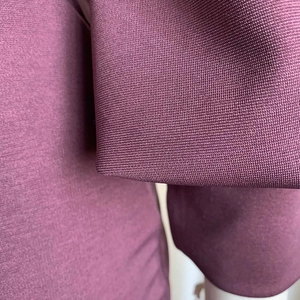 Primer plano del tejido de punto morado oscuro que muestra la textura fina y calidad
