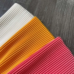 Gros plan détaillé de la texture plissée du tissu en blanc, jaune et rose corail