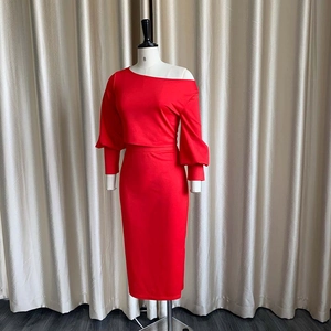Detalle de top rojo con hombros descubiertos y falda ajustada de talle alto