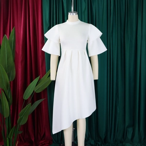 Detail of white dress with layered ruffle sleeves and asymmetric hem on a mannequin