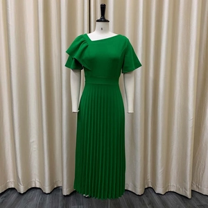 Detail of green pleated dress featuring ruffled asymmetrical neckline and slim waistline
