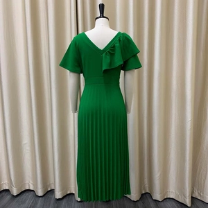 Detail view of emerald green pleated dress with back V-neck and ruffle shoulder detail