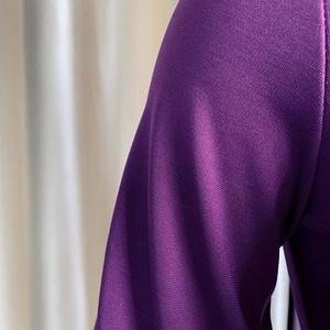 Primer plano detallado de tela de punto fino morada con textura suave y brillo ligero