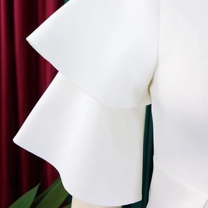 Close-up of white dress showing elegant double-layered ruffle sleeves with textured fabric