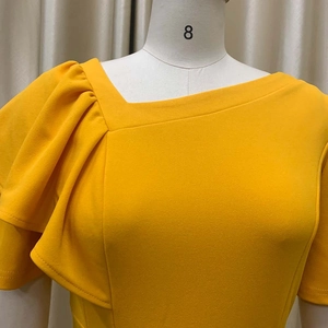 Detail of bright yellow ruffled sleeve and asymmetric neckline on summer dress