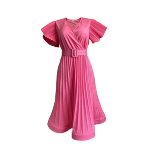 Détail d'une robe mi-longue plissée rose avec col en V, manches volantées et ceinture