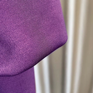 Vista macro de la fina textura del tejido de punto morado y la estructura del material