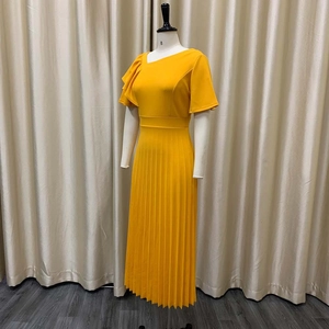 Detail view of yellow pleated dress with asymmetric ruffle sleeves and high waist design