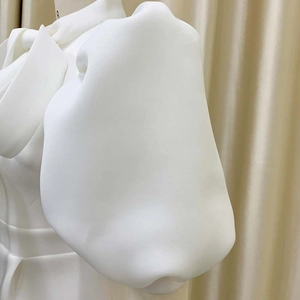 Detail of white puff sleeves and bow neckline on a structured summer party dress