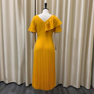 Detail of elegant bright yellow pleated maxi dress with ruffle shoulder and V-back design