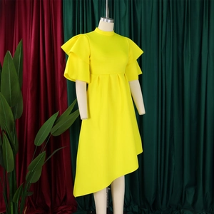 Detail of yellow dress with layered ruffle sleeves and asymmetrical pleated hemline
