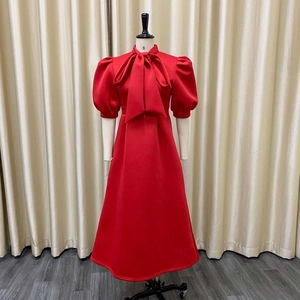 Detail of red party dress showing elegant bow neckline and puff sleeves for formal events