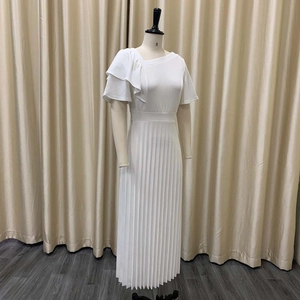 Detail of white asymmetric dress with ruffled shoulder and pleated skirt design