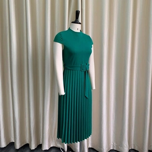 Détail d'une robe plissée vert foncé avec ceinture assortie et boucle carrée