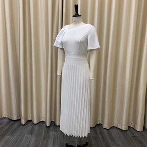 Detailed view of the elegant ruffled short sleeve and pleated texture on white dress