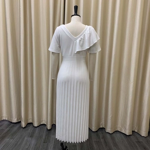 Back view of a white pleated dress featuring a deep V-neck and ruffled shoulder detail