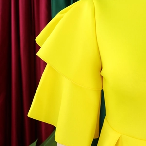 Detail view of the yellow dress featuring layered three-tier ruffled butterfly sleeves