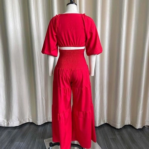 Dettaglio del set rosso due pezzi con top corto a maniche a sbuffo e pantaloni larghi a vita alta