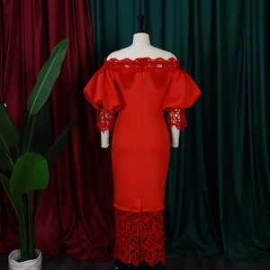 Detail of red off-shoulder dress featuring intricate lace lantern sleeves and hemline