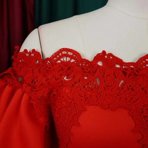 Close-up of red off-shoulder evening dress with floral lace detailing and lantern sleeves