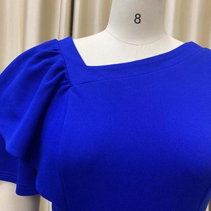 Detail of royal blue asymmetric ruffled neckline and pleated sleeve texture on dress