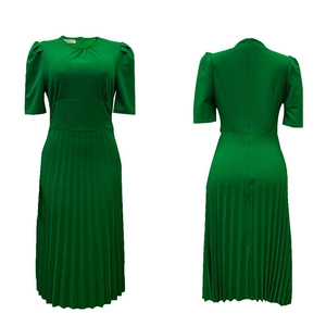 Detail van groene geplooide midi-jurk met pofmouwen en elastisch taille-ontwerp