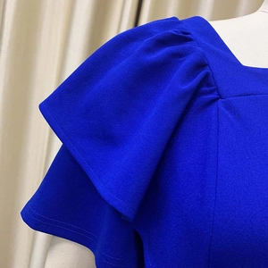 Detail of square neck and ruffled sleeves on this royal blue pleated dress