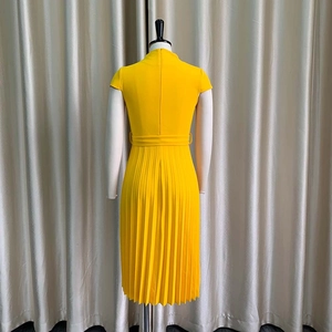 Détail de la robe midi plissée jaune avec ceinture assortie et manches courtes