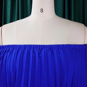 Détail de la texture plissée d'une robe bleu roi à épaules dénudées sur un mannequin