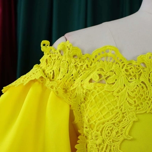 Detail of delicate yellow lace embroidery and off-shoulder sleeve on evening dress