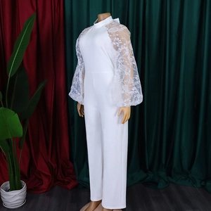 Detail of elegant white jumpsuit with sheer lace puff sleeves and floral embroidery