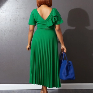 Detail of emerald green pleated dress featuring elegant ruffled shoulder and deep V-back