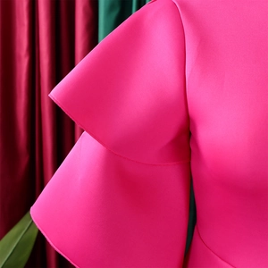 Detail of rose pink dress featuring double-layered ruffle sleeves and premium fabric