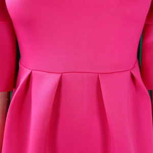 Detailed close-up of pleated waist and high-quality fabric on rose red dress