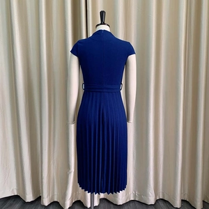 Détail d'une robe bleu marine à manches courtes avec jupe plissée et ceinture vue de dos