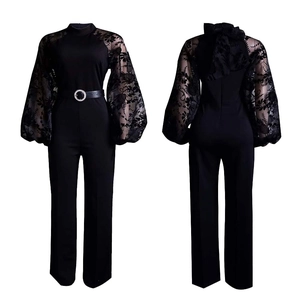 Detail of elegant black jumpsuit featuring floral lace sleeves and silver buckle belt