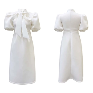 Close-up of elegant white midi dress featuring puff sleeves and a large bow tie collar