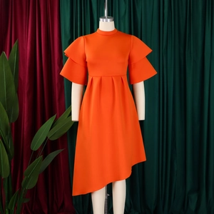 Detail of bright orange dress with double layer ruffle sleeves and asymmetric high collar