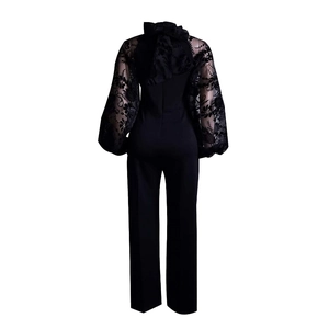 Detailed back view of black jumpsuit showing neck bow and sheer floral embroidery sleeves