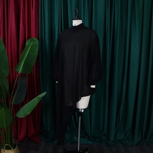 Detail van zwarte chiffon tuniek met asymmetrische zoom en elegante lantaarnmouwen