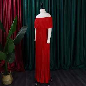 Détail d'une robe longue plissée rouge à épaules dénudées avec décolleté à volants chic