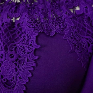 Detailed close-up of purple lace embroidery and floral patterns on the dress sleeve