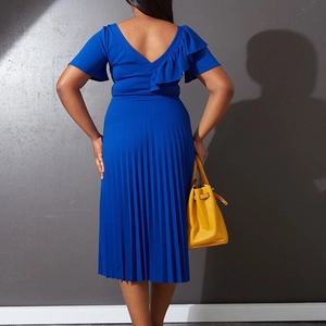 Detail of royal blue pleated dress with V-back design and elegant ruffle sleeve textures