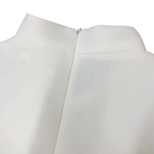 Detail of invisible zipper closure and stand collar seam on white dress back