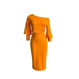Detalle del conjunto naranja de top con hombros descubiertos y falda midi ajustada