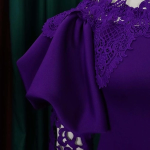 Detailansicht des dunkelvioletten Kleides mit floraler Spitze am Ausschnitt und Puffärmeln