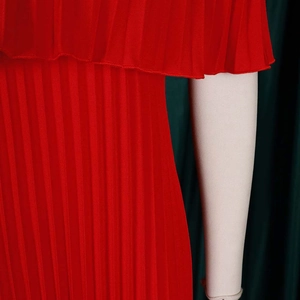 Gros plan sur la texture du tissu plissé rouge et le design multicouche de la robe