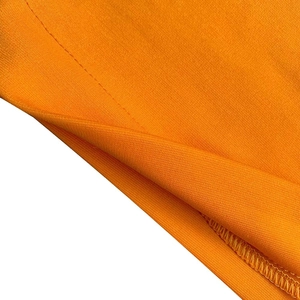 Primer plano detallado de la tela de punto naranja con costuras y acabado de bordes