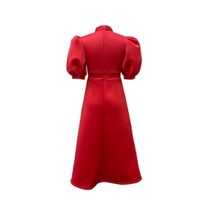 Detail of the back of a red formal dress featuring a high collar and hidden zipper